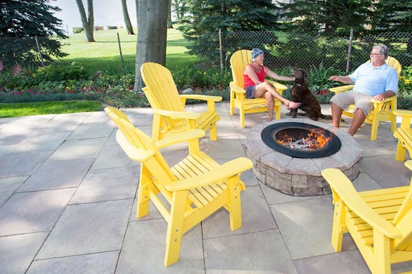 Couple with their dog enjoying a fire in a Belvedere Fire Pit