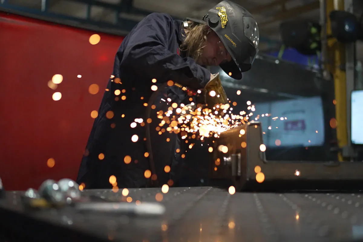 image of sparks flying while person works on steel part