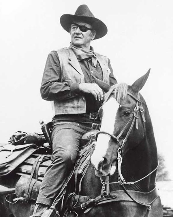 John Wayne riding a horse