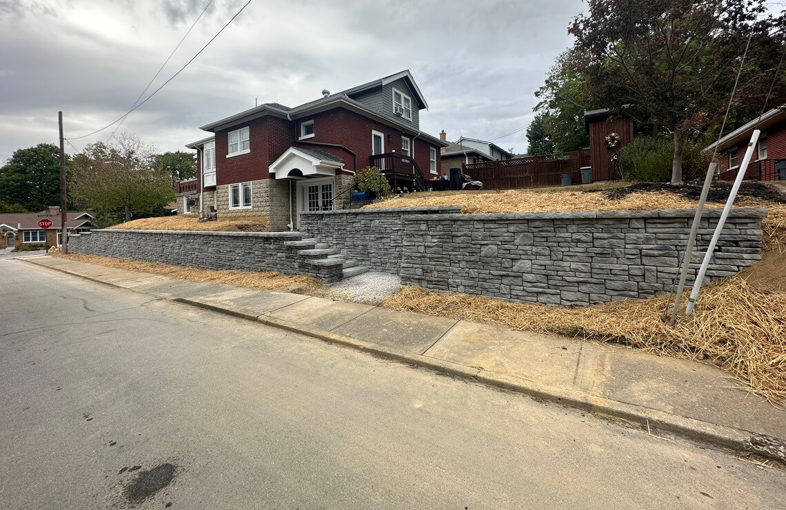 image of alpine textured Novum retaining wall and stairs in front of house