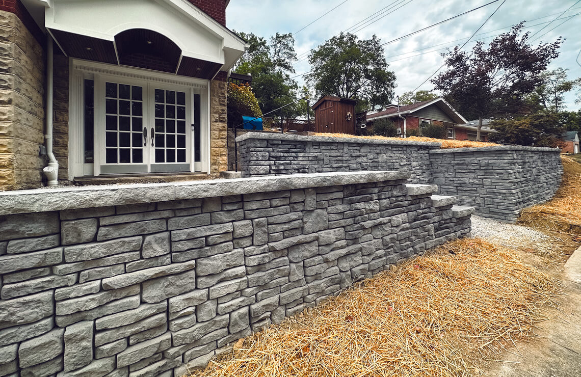 image of alpine textured Novum retaining wall in front of house