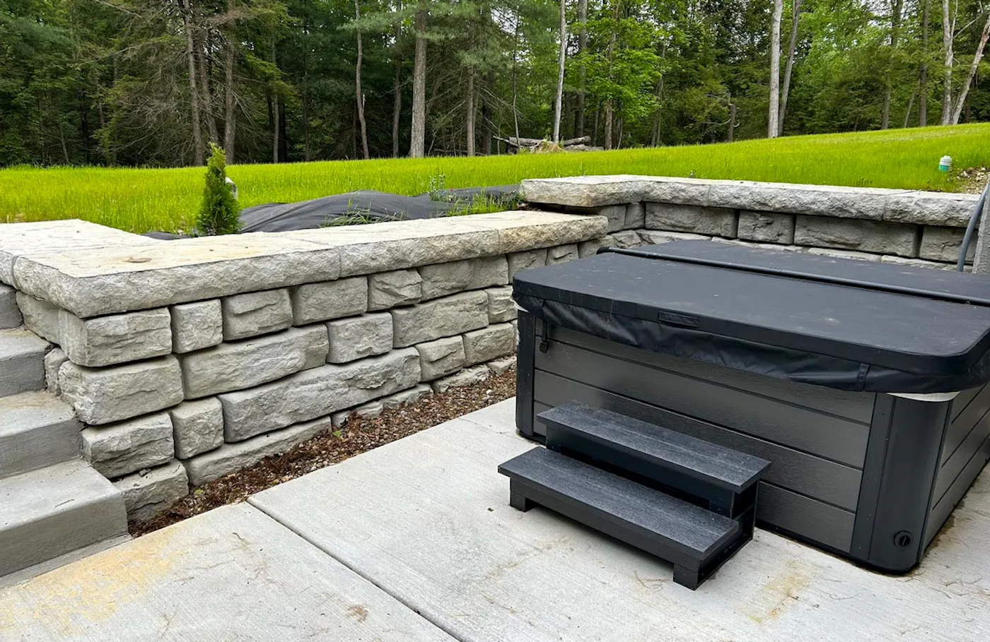 image of novum wall with cap in backyard with hot tub