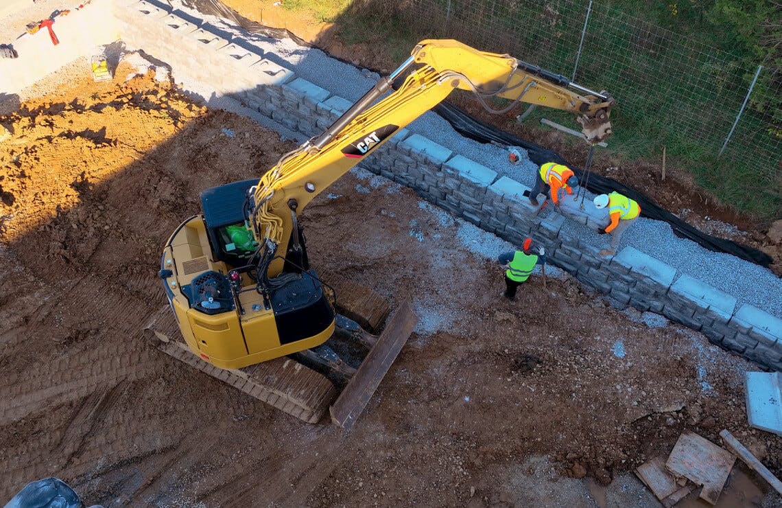 image of mini excavator installing novum wall
