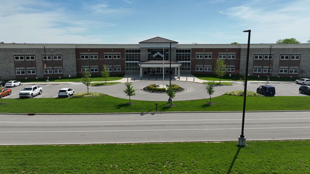 drone image of school with pole base light pole bases along road