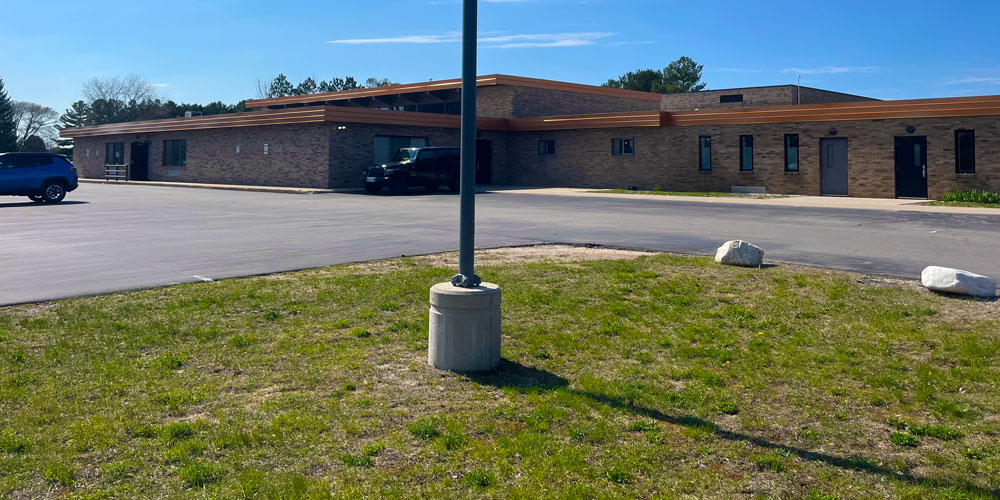 image of Pole Base light pole base in front of old school parking lot