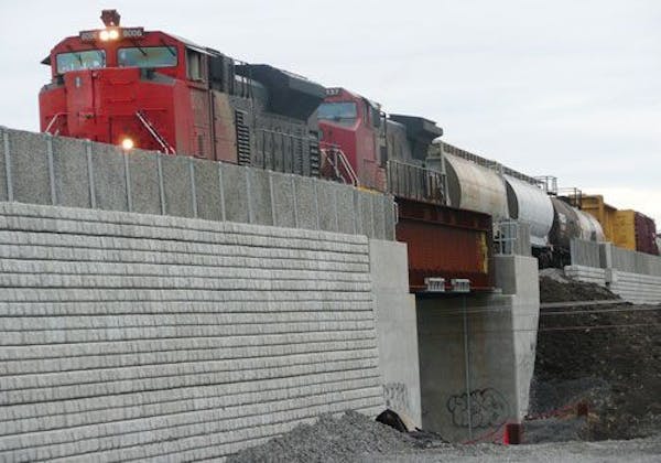 A train drives over a bridge, upheld by Cobblestone retaining walls
