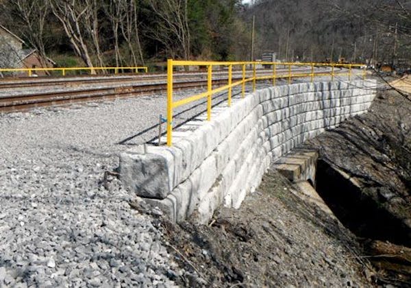Limestone wall supporting train track over culvert