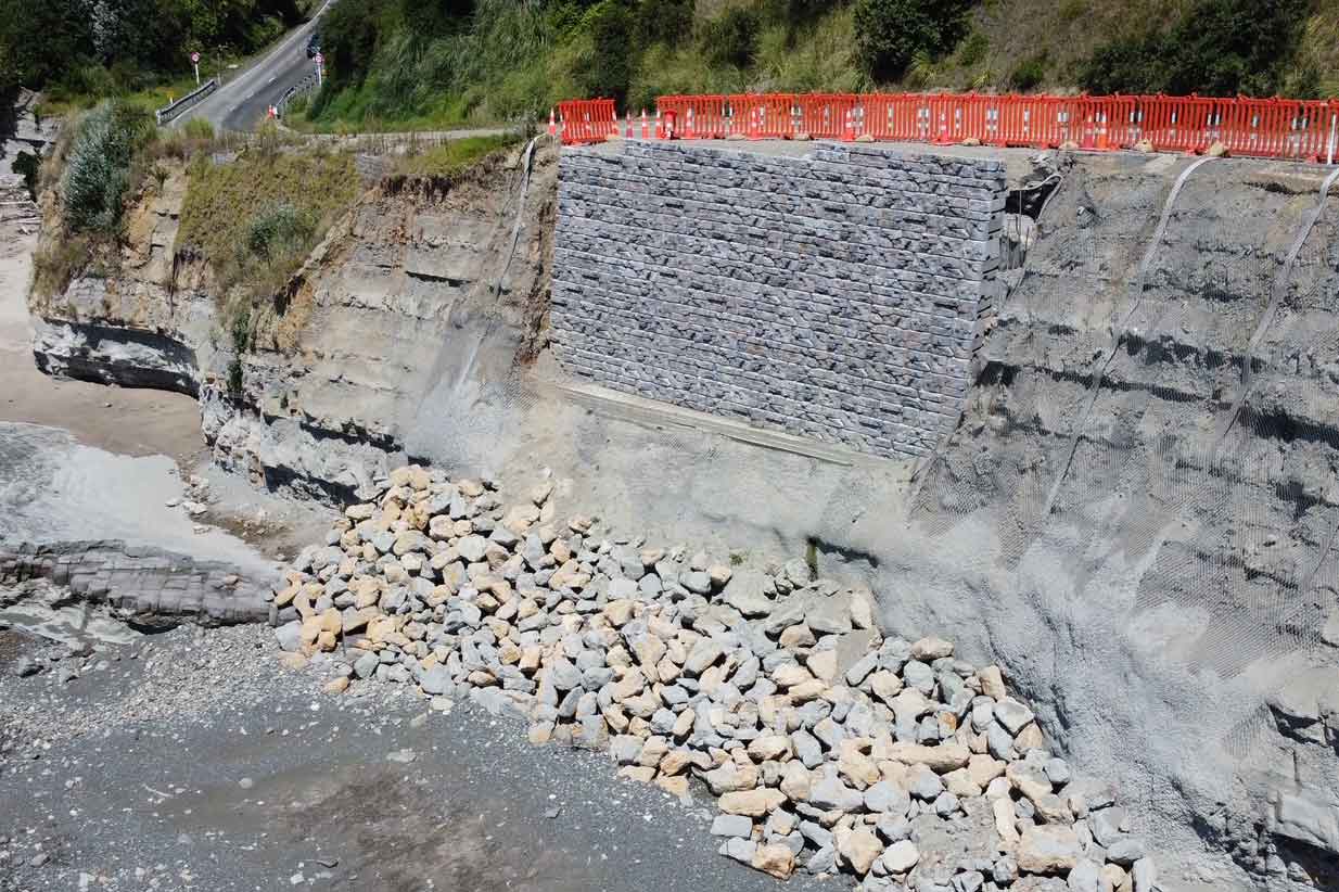 A retaining wall anchored to a cliff along New Zealand's Pacific Coast