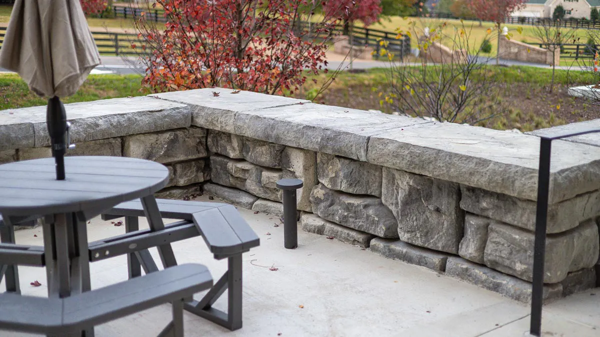 A Redi-Rock seat wall with cap blocks encloses a cozy picnic area. 