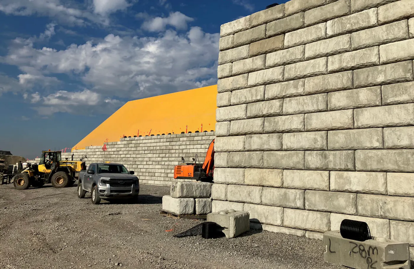 image of limestone redi-rock wall being installed with excavators