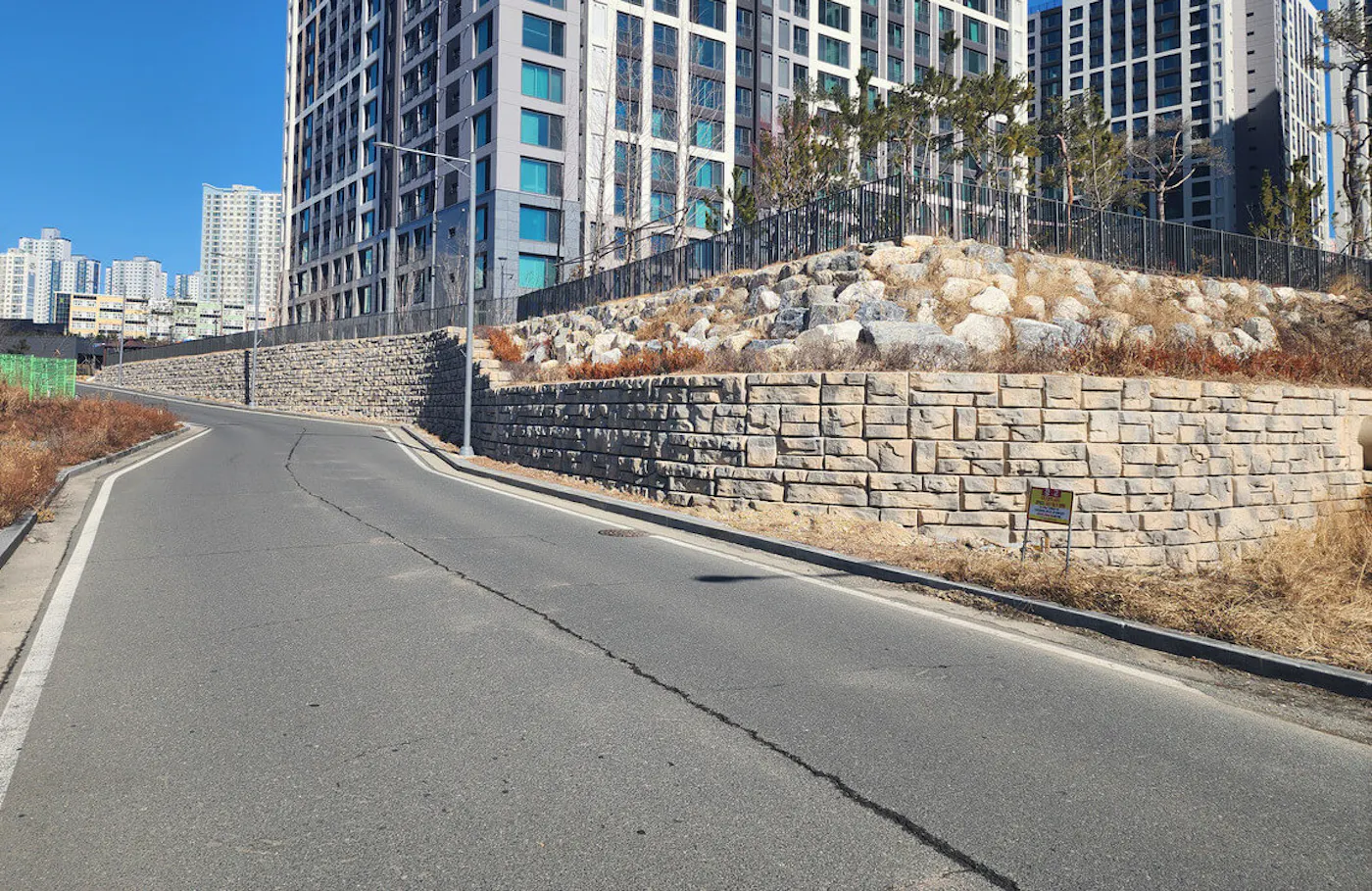 image of ledgestone redi-rock wall next to road and skyscrapers in background
