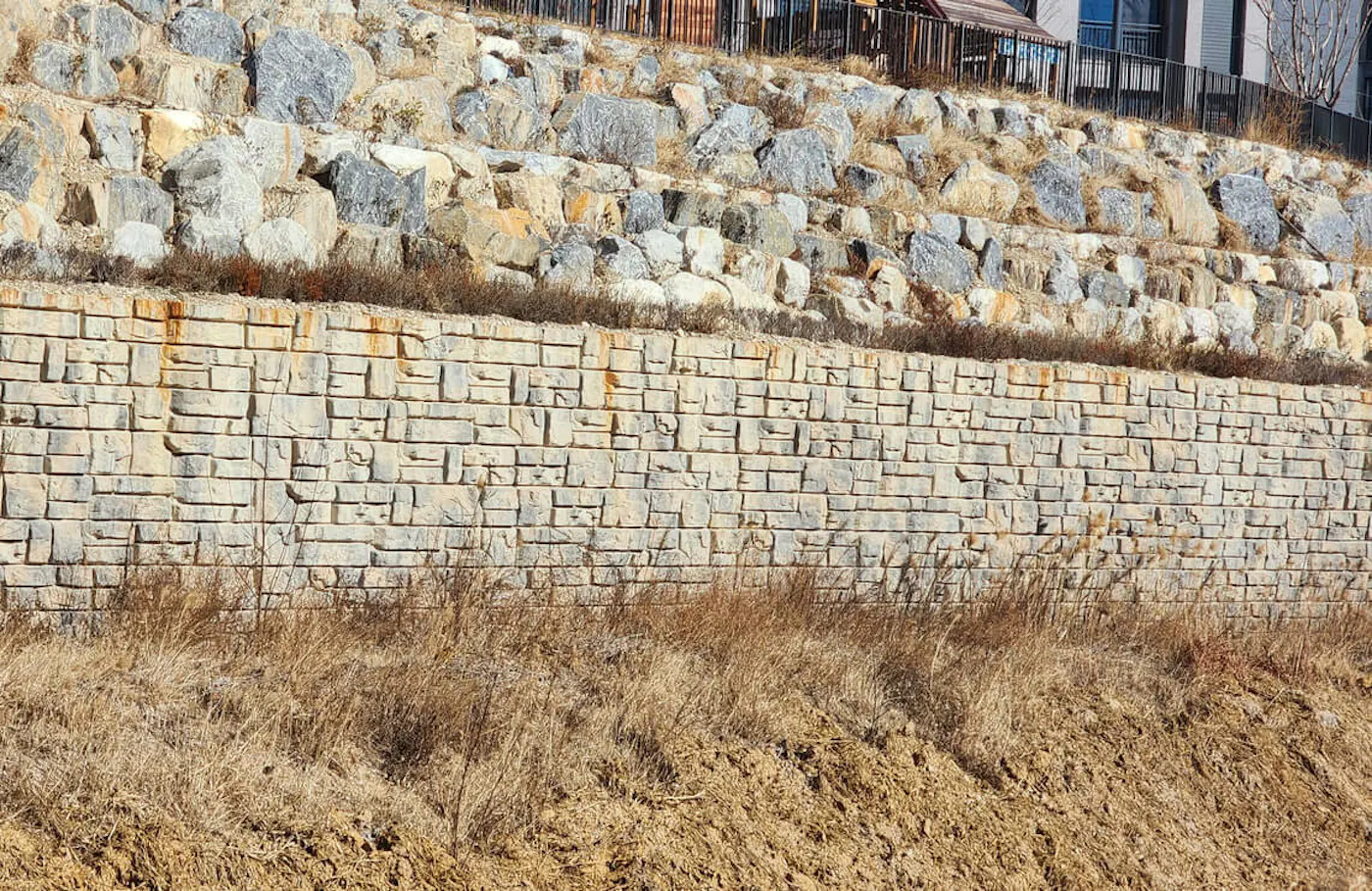 image of redi-rock ledgestone wall with boulders above wall