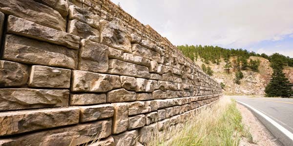 image of ledgestone textured redi-rock wall next to road