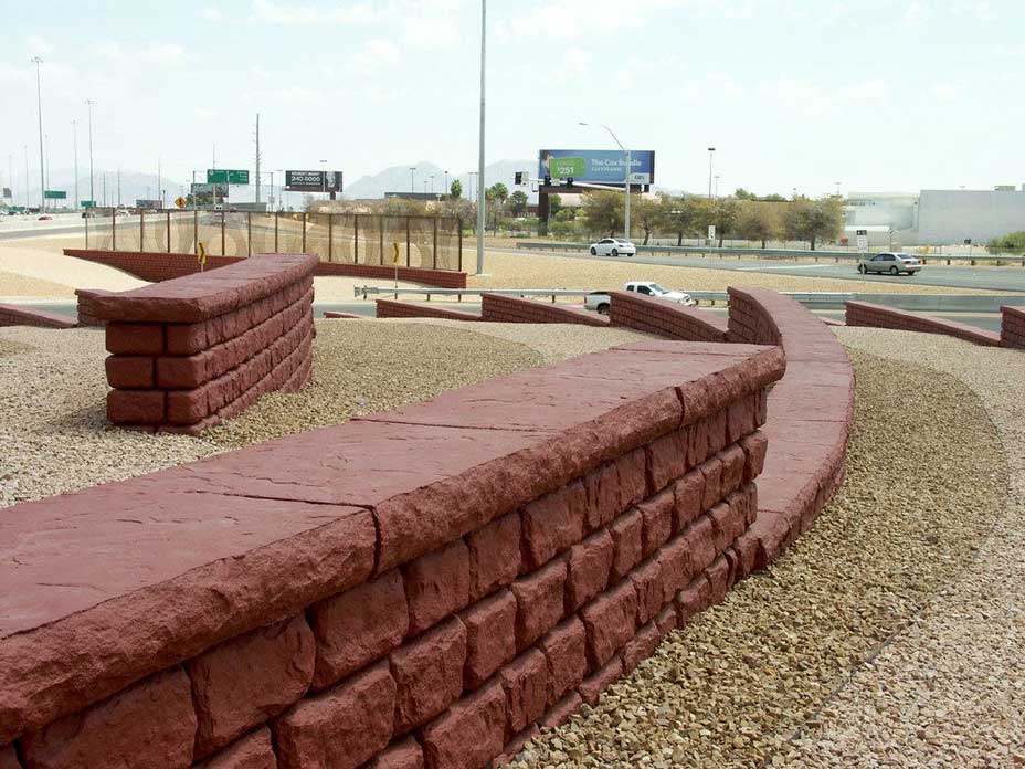 Freestanding walls with caps and red coloring along freeway