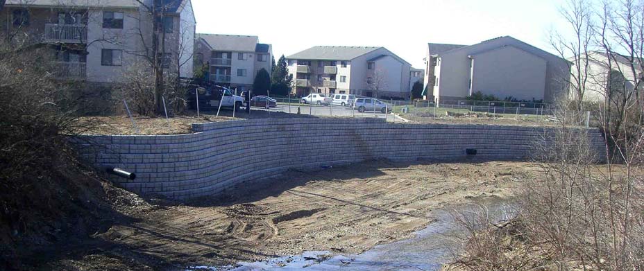 Cobblestone retaining wall built for erosion control at apartment complex