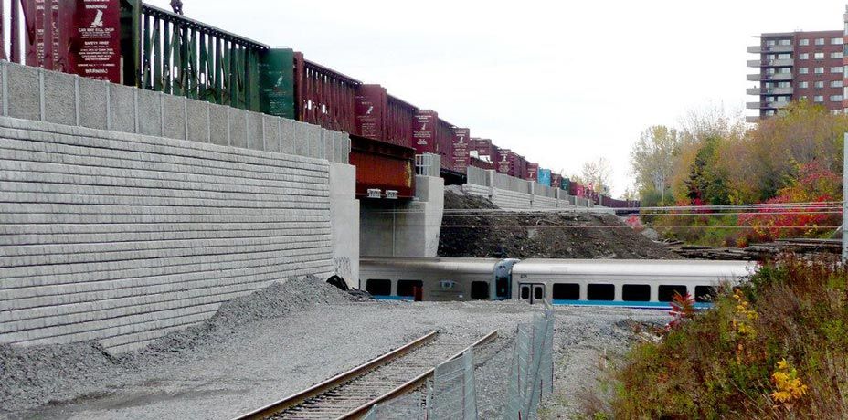 Cobblestone retaining wall supports rail train on track elevated above another train track