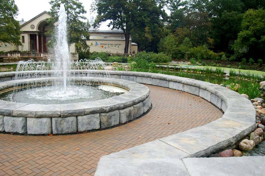Curved limestone blocks with caps provide seating around zoo fountain