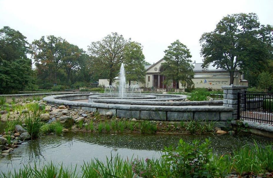 Curving freestanding walls in limestone texture ring a fountain at the Philadelphia Zoo