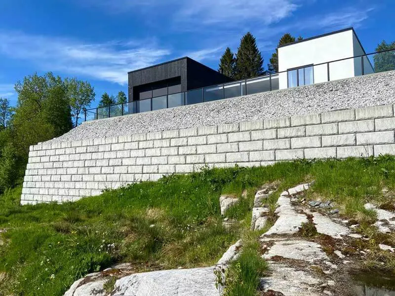 image of limestone textured redi-rock retaining wall with building on top