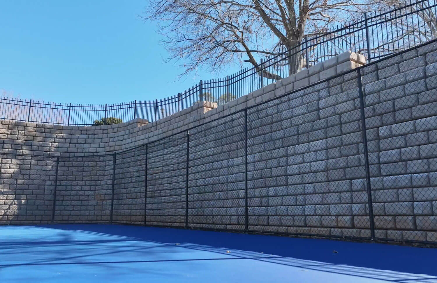 image of redi-rock XL wall surrounding tennis court 
