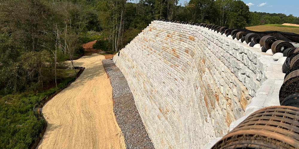 image of tall redi-rock ledgestone retaining wall with geogrid on top