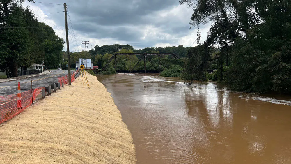 image of flooded river next to road with bridge