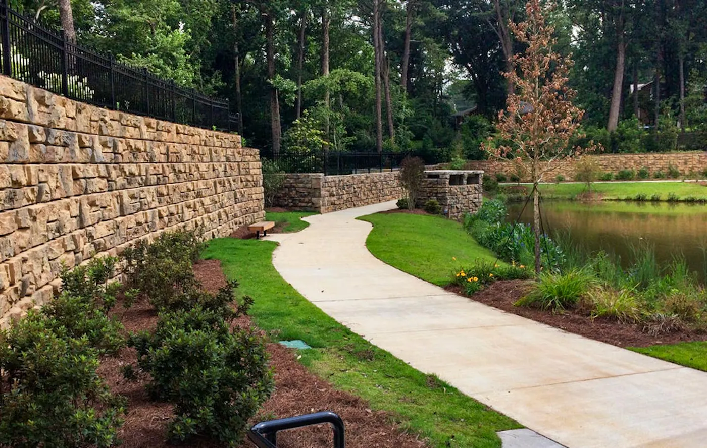 image of sidewalk along creek lined with redi-rock walls