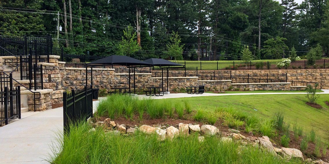 image of sidewalk with tables and chairs lined with redi-rock walls
