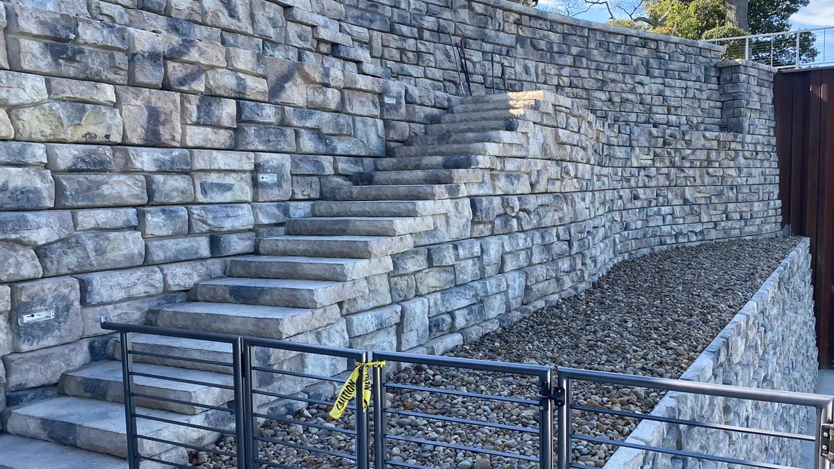 A massive lakeshore Redi-Rock retaining wall features steps and cap units for a cohesive look. 