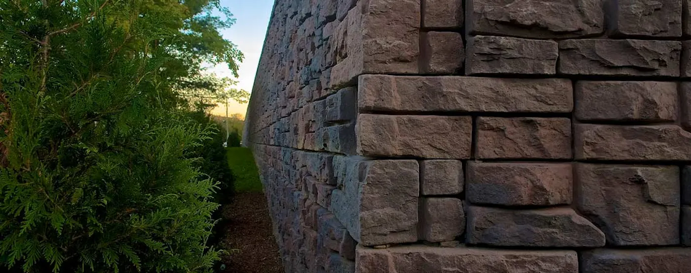 image of corner of redi-rock retaining wall with trees on the left