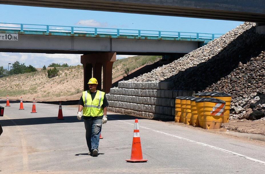 Construction worker walking with retaining wall in background