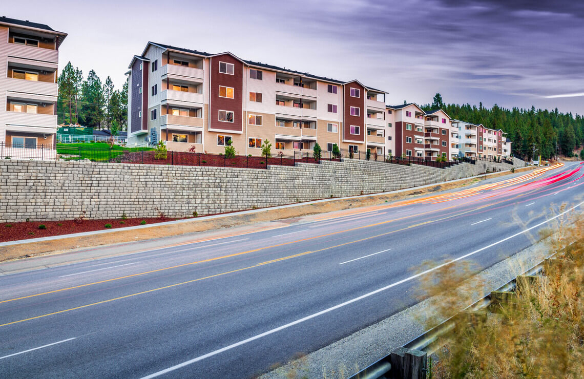 image of redi-rock wall with buildings on top next to road
