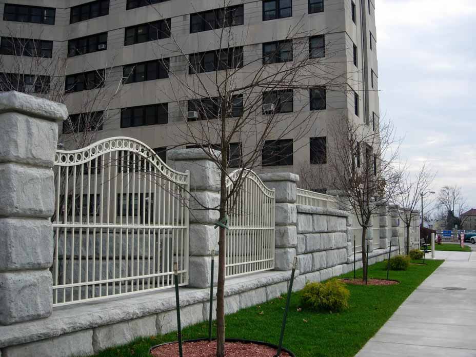 Freestanding Limestone retaining walls incorporate fencing to enclose a Veterans Memorial at a VA Medical Center in Buffalo, NY