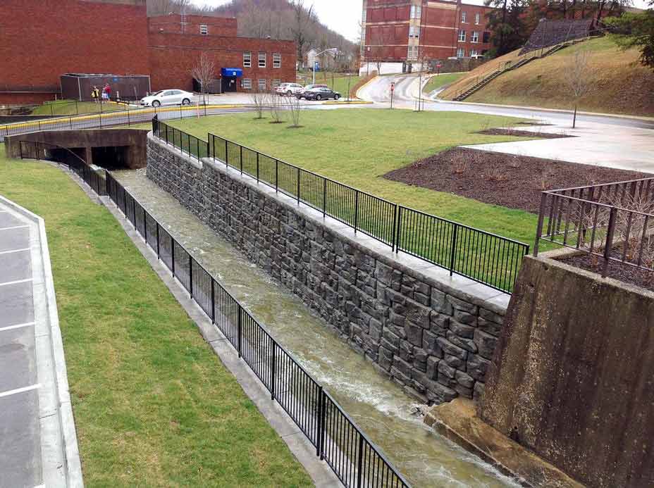 Aesthetic Ledgestone retaining wall supporting storm channel at Morehead State University