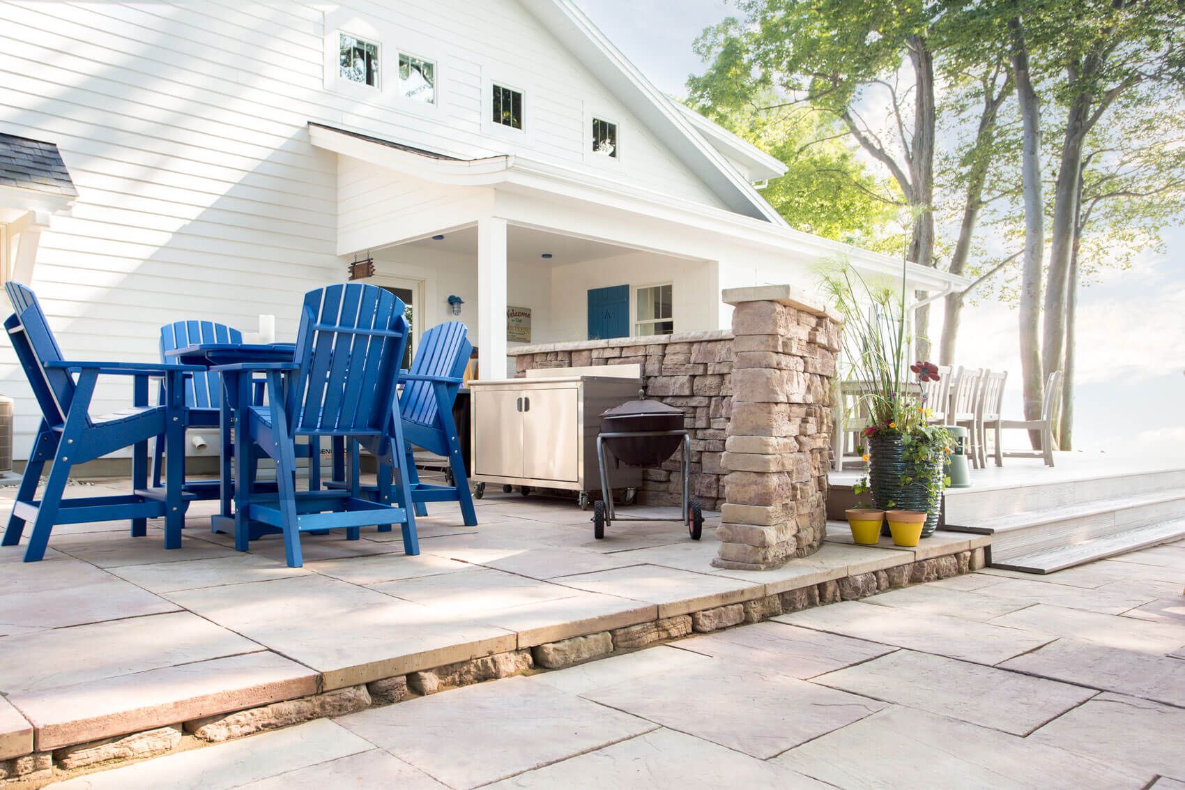 24x24 flagstone for outdoor kitchen area with tables chairs and grill