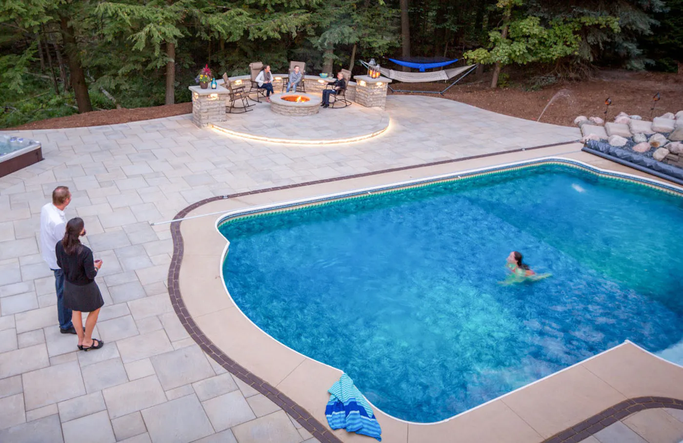 family at swimming pool and fire pit with amaro pavers
