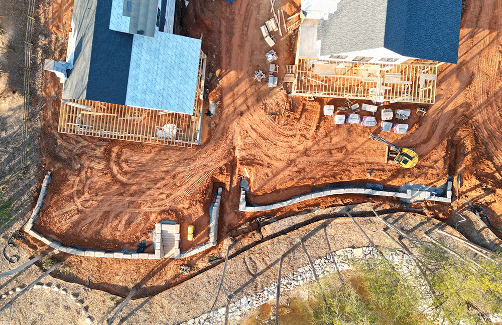 aerial image of construction site with two walls and two houses