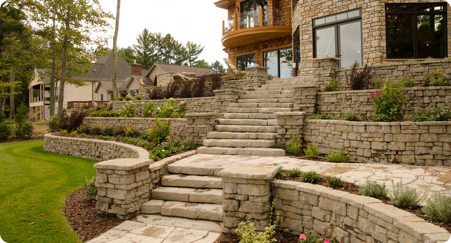 backyard of home with irregualr step stairway with tiered belvedere walls and columns