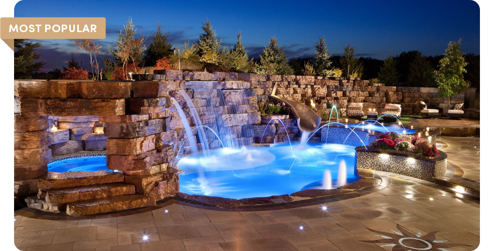 outcropping wall with waterfall leading to pool at night