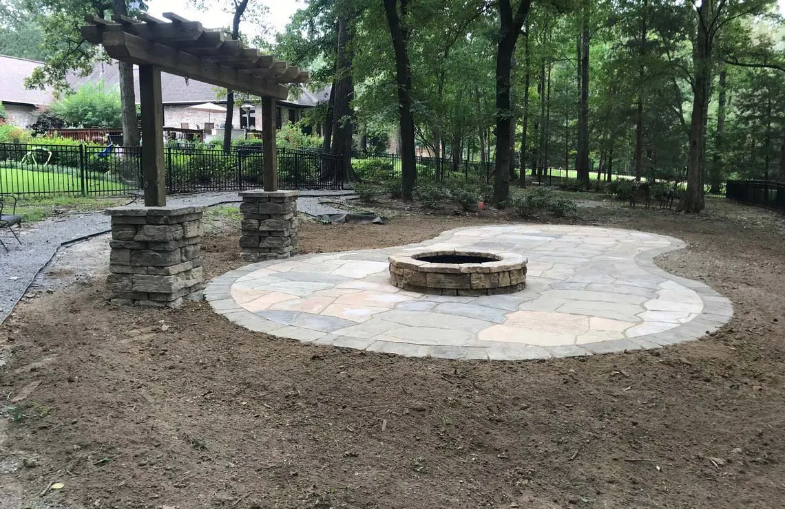 Rosetta Hardscapes Belvedere wall and corner blocks create a column and pergola feature and a Grand Flagstone patio with Belvedere Fire Pit kit create ample room for enjoyment. 