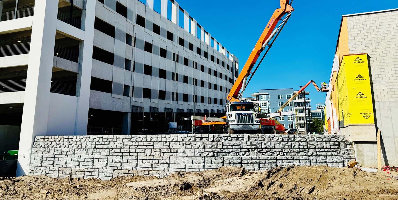 image of redi-rock wall being installed next to buildings