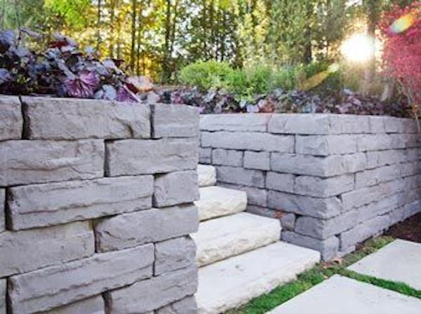 Kodah retaining wall with dimensional steps in yard with plants
