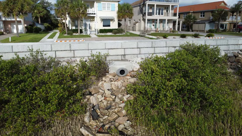Redi-Rock retaining wall with a stormwater outfall pipe extending through the wall to help manage tidal flooding and roadway drainage.