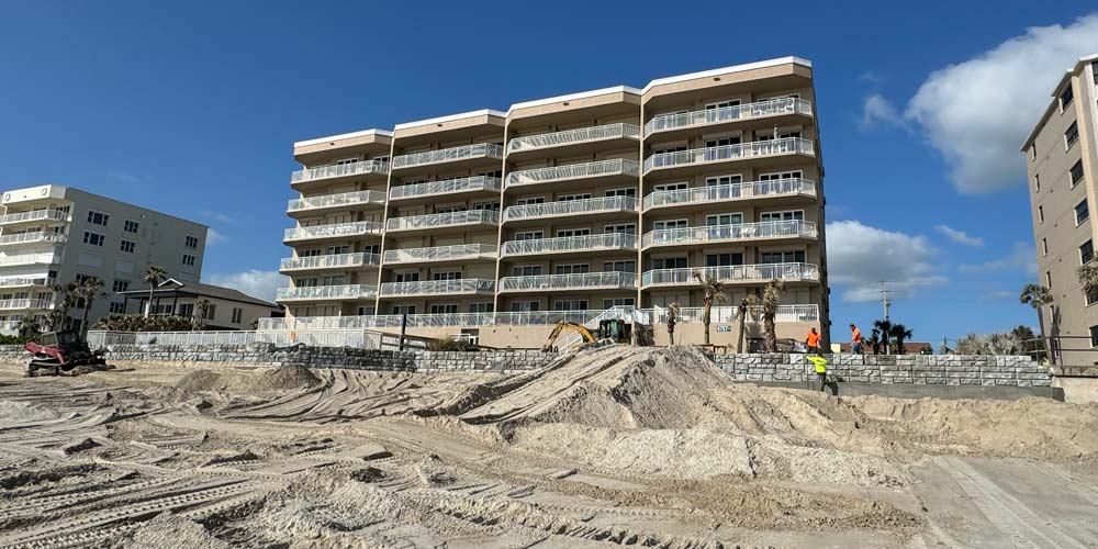 image of hotel on beach with redi-rock and coast armor being installed in front of hotel