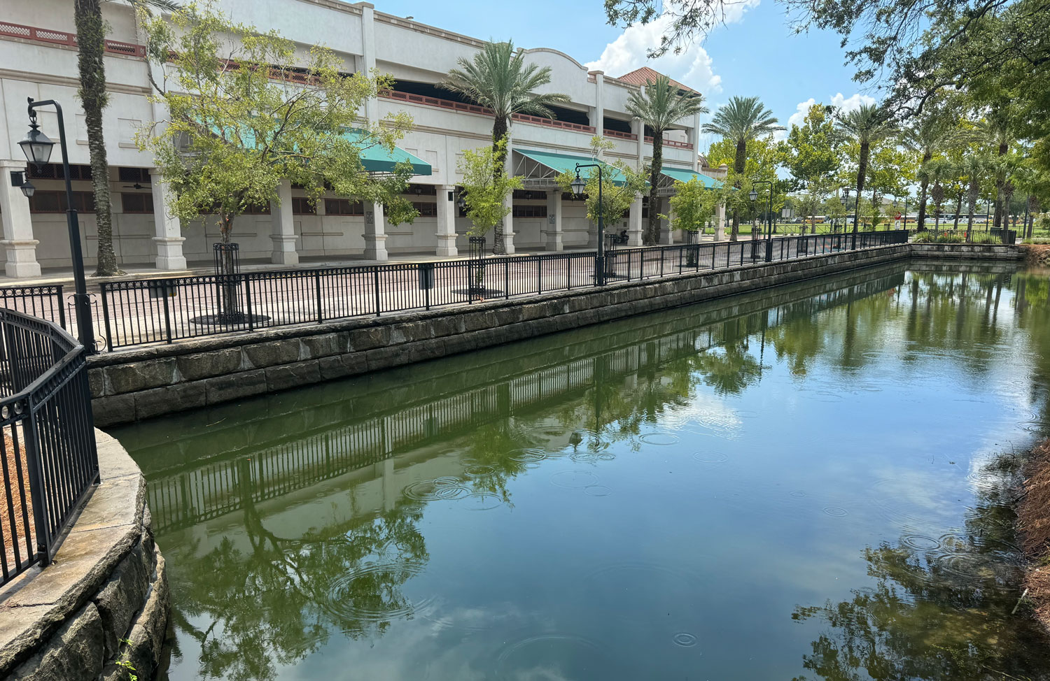 image of large building and walkway with retention basin of redi-rock blocks