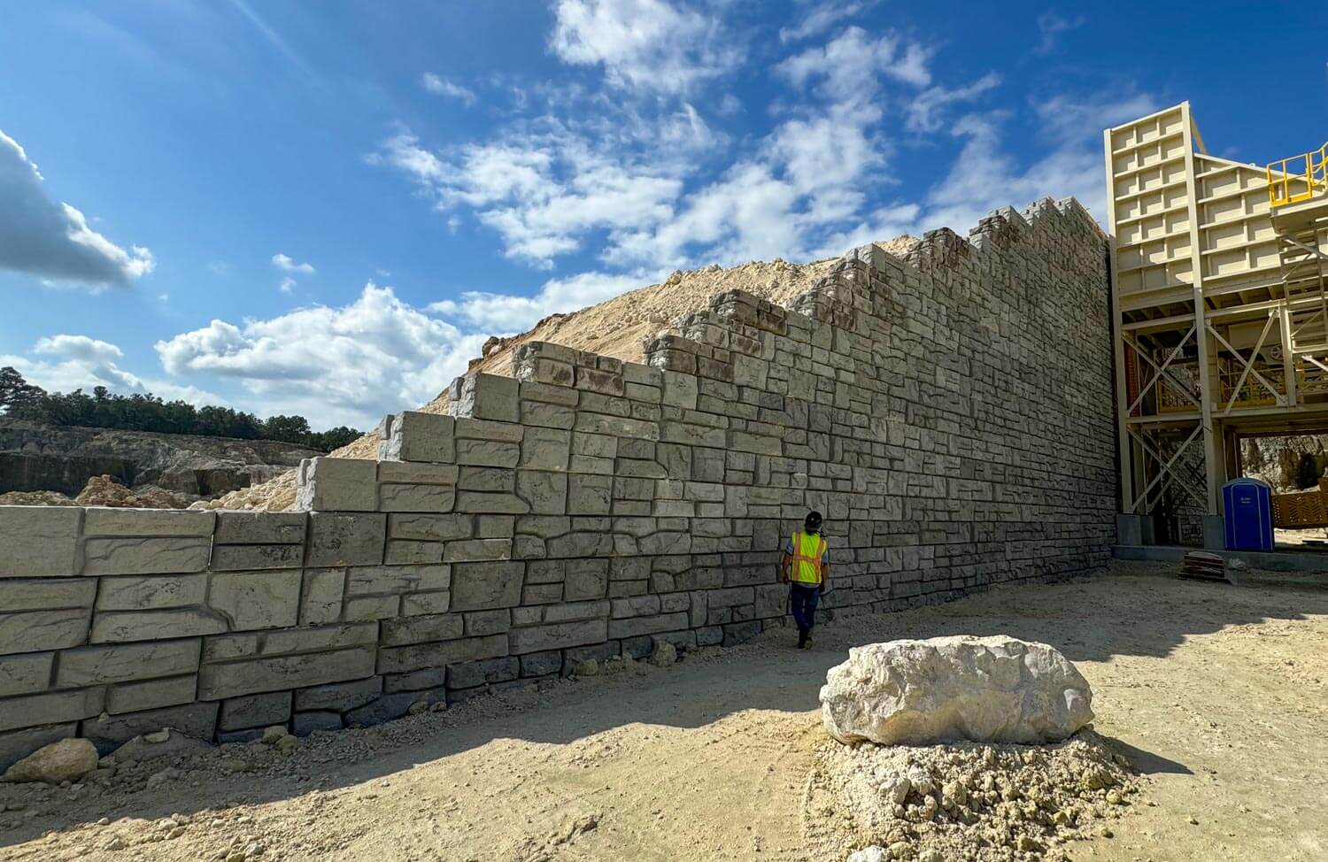 image of person standing in front of tall redi-rock wall for stone quarry