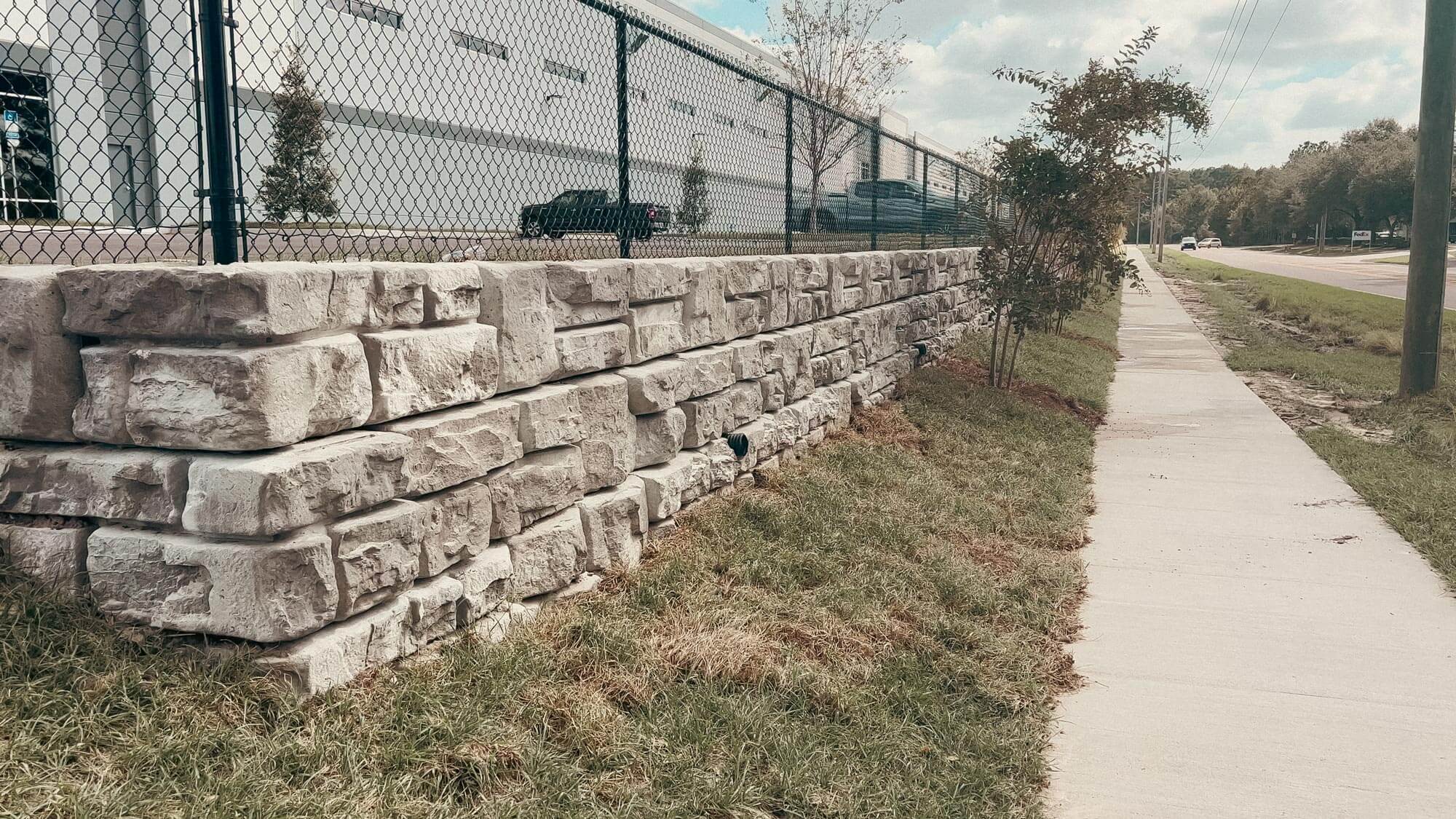 Image of redi-rock retaining wall by Truemont Materials for warehouse parking lot