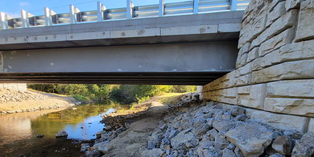 A completed Velpont bridge featuring streambanks, riprap, and the bridge’s substructure.