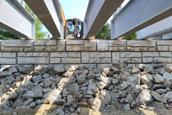 Velpont bridge installation close-up showing connection bars and construction equipment in the background
